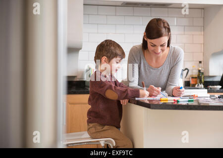 Mutter und Sohn Zeichnung zusammen in der Küche Stockfoto