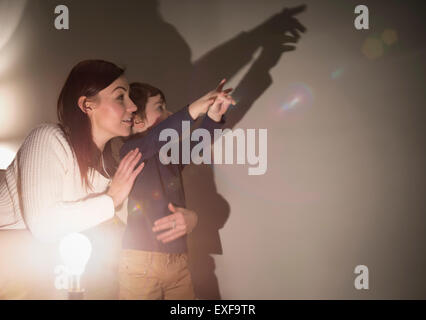 Mutter und Sohn machen tierische Schatten an Wand Stockfoto