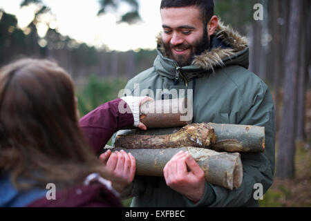 Junge Wandern paar sammeln Protokolle für Lagerfeuer im Wald Stockfoto