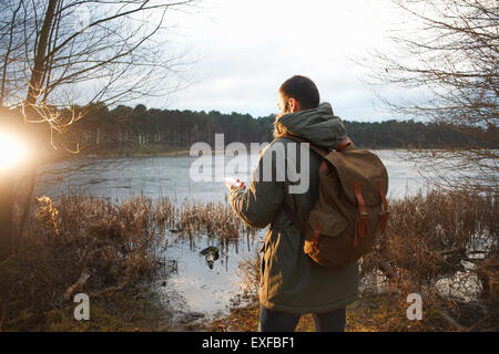 Junge männliche Wanderer am See Karte lesen Stockfoto