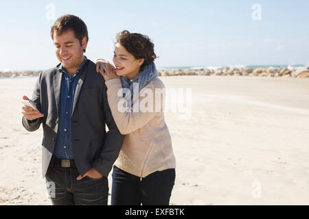 Junges Paar lesen Smartphone Texte am Strand, Tel Aviv, Israel Stockfoto