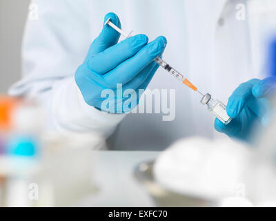Arzt vorbereiten eines Impfstoffs in einem Patienten zu injizieren Stockfoto
