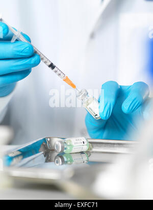 Nahaufnahme von Ärzten Händen Vorbereitung eines Impfstoffs, Patienten zu injizieren Stockfoto