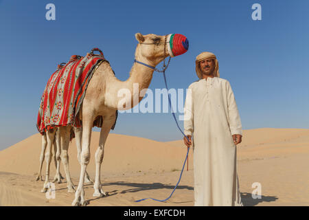 Porträt der Beduine mit Kamel in der Wüste, Dubai, Vereinigte Arabische Emirate Stockfoto