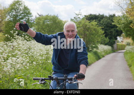 Ältere Mann Reiten Fahrrad auf Feldweg Stockfoto