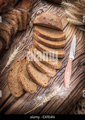 In Scheiben Schwarzbrot auf der alten Holzbrett. Stockfoto