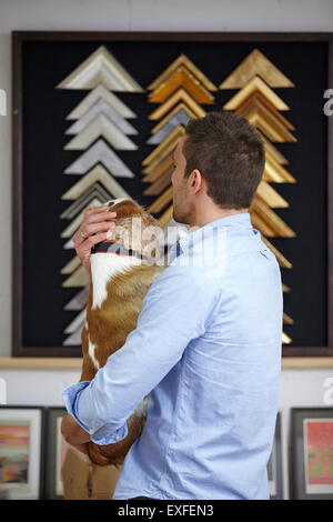 Mann mit Hund, während Rahmen im Bild Einrahmer Workshop auswählen Stockfoto