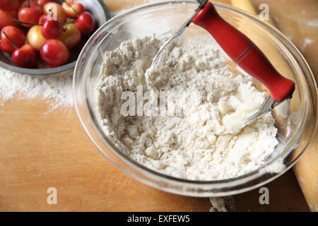 Schneiden Butter in Mehl zu Teig Kruste für Kirschkuchen, Textfreiraum enthalten Stockfoto