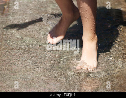 des Mädchens Füße spielen in den Brunnen Nahaufnahme auf Sommertag Stockfoto