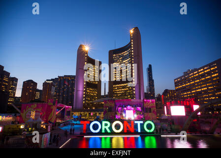 TORONTO, Kanada-Juli 9,2015: Das neuen Toronto Zeichen in Nathan Phillips Square feiert die PanAm-Spiele des neuen Rathauses am Rücken. Bühne montiert statt eine konstante Partei namens Panamania Stockfoto