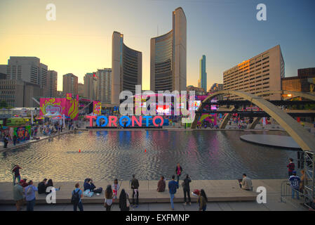 TORONTO, Kanada-Juli 9,2015: Das neuen Toronto Zeichen in Nathan Phillips Square feiert die PanAm-Spiele des neuen Rathauses am Rücken. Bühne montiert statt eine konstante Partei namens Panamania Stockfoto