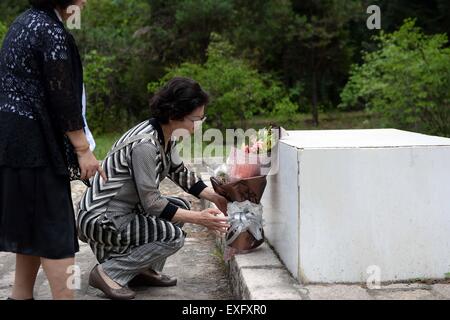 (150714)--HARBIN, 14. Juli 2015 (Xinhua)--ein japanische Bürger, die während des zweiten Weltkriegs vom chinesischen Volk angenommen wurde, legt einen Kranz auf ein Grab, wie sie einen Friedhof um chinesische Adoptiveltern in Fangzheng County in der Nähe von Harbin, der Hauptstadt des nordöstlichen Chinas Provinz Heilongjiang, 13. Juli 2015 merken besuchen. Eine Gruppe von 54 japanischen Bürgerinnen und Bürger, alle jetzt Waisen, einen Besuch der Gräber von ihren Adoptiveltern chinesischen hier am Montag bezahlt. Verlassen von ihren leiblichen Eltern während der eiligen Rückzug am Ende des zweiten Weltkrieges im Jahr 1945, wurden die Waisen, jetzt über 70 Jahre alt, aufgenommen und aufgeworfenen t Stockfoto