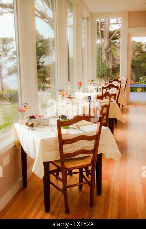 Reihe von Esstischen entlang der großen Panoramafenster im Meer B & B Bed &amp; Breakfast inn Stockfoto