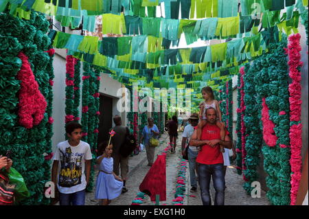 (150714)--TOMAR, 14. Juli, 2015(Xinhua)--Menschen zu Fuß entlang der Straße, während Tabuleiros Festival in Tomar, Portugal, 12. Juli 2015 mit Papierblumen dekoriert. Das zehntägige Tabuleiros Festival geschlossen hier am 13. Juli, zieht Besucher aus der ganzen Welt. (Xinhua/Zhang Liyun) Stockfoto