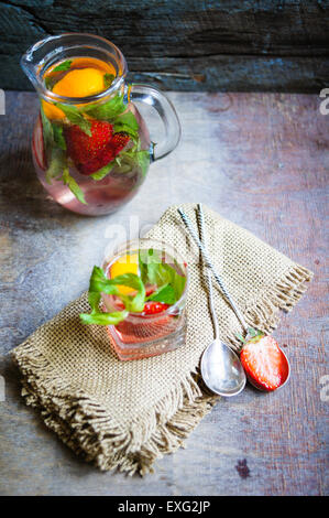 Limonade mit frischen Erdbeeren, Zitrone und Minze. Rustikaler Hintergrund Stockfoto