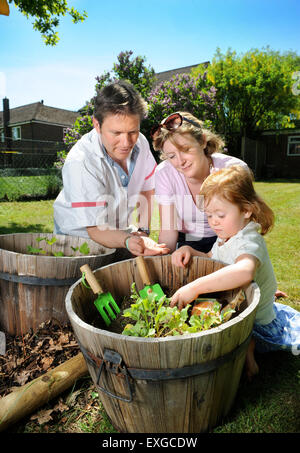 Eine Familie mit Tochter Pflanzen Samen in ihren Garten, Gloucestershire UK Stockfoto