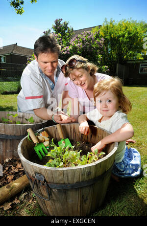 Eine Familie mit Tochter Pflanzen Samen in ihren Garten, Gloucestershire UK Stockfoto