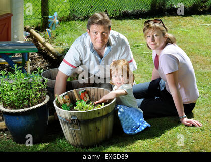 Eine Familie mit Tochter Pflanzen Samen in ihren Garten, Gloucestershire UK Stockfoto