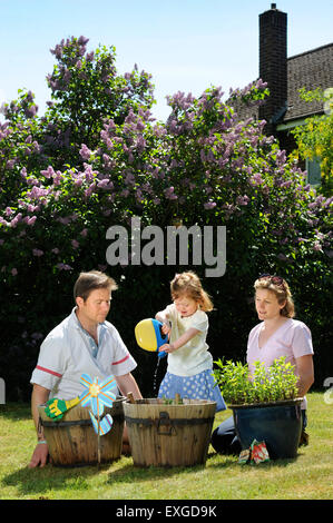 Eine Familie mit Tochter Pflanzen Samen in ihren Garten, Gloucestershire UK Stockfoto