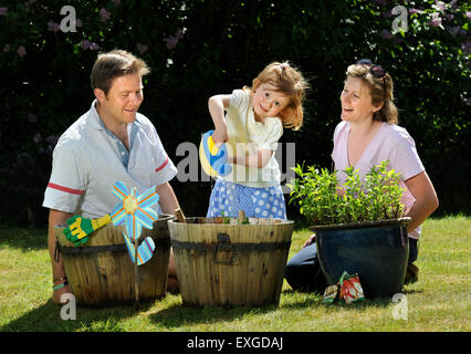 Eine Familie mit Tochter Pflanzen Samen in ihren Garten, Gloucestershire UK Stockfoto