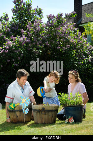 Eine Familie mit Tochter Pflanzen Samen in ihren Garten, Gloucestershire UK Stockfoto