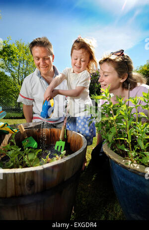 Eine Familie mit Tochter Pflanzen Samen in ihren Garten, Gloucestershire UK Stockfoto