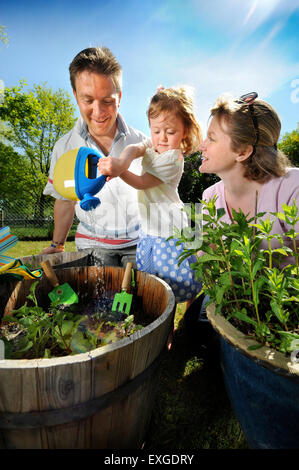 Eine Familie mit Tochter Pflanzen Samen in ihren Garten, Gloucestershire UK Stockfoto