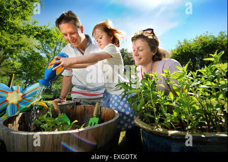 Eine Familie mit Tochter Pflanzen Samen in ihren Garten, Gloucestershire UK Stockfoto