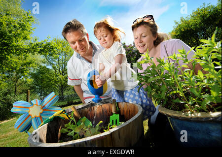 Eine Familie mit Tochter Pflanzen Samen in ihren Garten, Gloucestershire UK Stockfoto