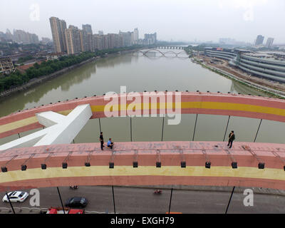 Jinhua, China. 14. Juli 2015. Ein Mann steht auf der Oberseite eine Brücke und springen in den Fluss in Jinhua, Zhejiang Provinz, 14. Juli 2015 wollen.  Der Mann fand um 14:00 auf der Oberseite und zu Fuß auf den Boden auf 17:22 nach der Polizist ihn zu überzeugen. Der Grund ist noch nicht klar. Bildnachweis: Panda Auge/Alamy Live-Nachrichten Stockfoto