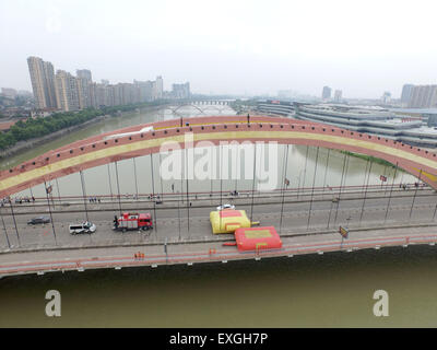 Jinhua, China. 14. Juli 2015. Ein Mann steht auf der Oberseite eine Brücke und springen in den Fluss in Jinhua, Zhejiang Provinz, 14. Juli 2015 wollen.  Der Mann fand um 14:00 auf der Oberseite und zu Fuß auf den Boden auf 17:22 nach der Polizist ihn zu überzeugen. Der Grund ist noch nicht klar. Bildnachweis: Panda Auge/Alamy Live-Nachrichten Stockfoto