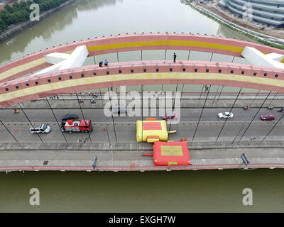 Jinhua, China. 14. Juli 2015. Ein Mann steht auf der Oberseite eine Brücke und springen in den Fluss in Jinhua, Zhejiang Provinz, 14. Juli 2015 wollen.  Der Mann fand um 14:00 auf der Oberseite und zu Fuß auf den Boden auf 17:22 nach der Polizist ihn zu überzeugen. Der Grund ist noch nicht klar. Bildnachweis: Panda Auge/Alamy Live-Nachrichten Stockfoto