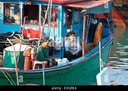 Chinesische Fischer und Frau haben Frühstück auf der Terrasse Ihrer kleinen Fischerboot günstig auf Cheung Chau Island, Hong Kong. Stockfoto