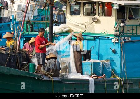 Besatzung eines chinesischen Fischerboot Austausch Netze auf einem kommerziellen Fischerboot auf Cheung Chau Island, Hong Kong. Stockfoto