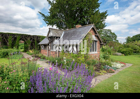 Urige Hütte, umgeben von Blumen im Garten Arley Hall in Cheshire, England. Stockfoto