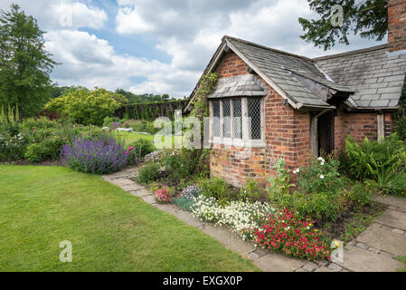 Urige Hütte, umgeben von Blumen im Garten Arley Hall in Cheshire, England. Stockfoto