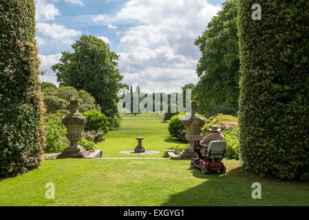 Ein älterer Mann in einem Elektromobil genießt die Aussicht bei Arley Hall Gardens in Cheshire, England an einem sonnigen Sommertag. Stockfoto