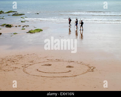 Sidmouth. Ein Smiley-Gesicht im Sand begrüßt Besucher an den Strand unter Jacobs Ladder, in Sidmouth, Devon. Stockfoto