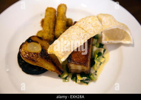 Platte Schweinebauch, Birne, Kroketten und Blutwurst im Anchor Pub Restaurant in Ripley Hautpstraße - GU23 UK Stockfoto