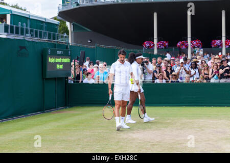 Serena Williams erwärmt sich für das Spiel auf Platz Nr. 5, geholfen durch Trainer Patrick Mouratoglou, während der Wimbledon Championships 2015 Stockfoto