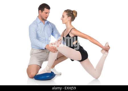 Schöne weibliche Ballett-Tänzerin und ihr Physiotherapeut isoliert auf einem weißen Hintergrund. Ballerina trägt einen schwarzen Anzug, poi Stockfoto