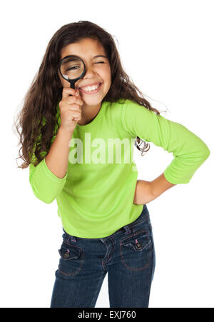 Ziemlich niedlich kaukasische Mädchen trägt ein grünes Langarm-Top und blaue Jeans. Sie spielt mit einer Lupe. Stockfoto