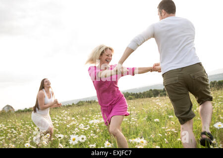 Glückliche Freunde, die Freizeit gemeinsam zu verbringen, in einem Feld Stockfoto