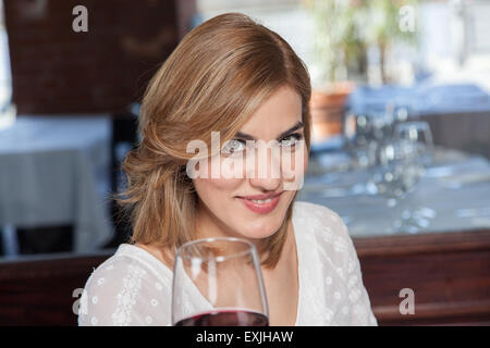 Hübsche Frau, die einen Becher Wein Stockfoto