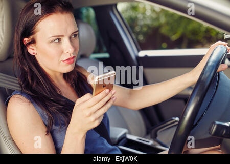 Frau mit Handy während der Fahrt Stockfoto
