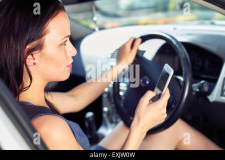 Frau mit Handy während der Fahrt Stockfoto