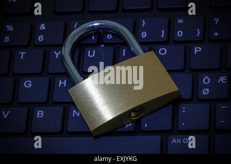Nahaufnahme der ein Vorhängeschloss auf einer Computertastatur mit blauen Farbton. Konzept-Foto von Technologie, Internet und Computer Sicherheit. Stockfoto