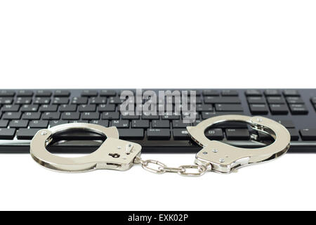 Metall-Handschellen auf einer Tastatur, isoliert auf weiss. Konzept-Foto von Computer, Internet & Cybercrime und Piraterie, hacking & Phishing. Stockfoto