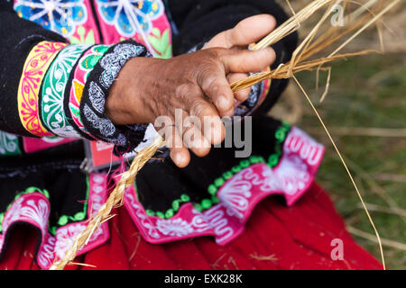 Indigene peruanische Frau machen Seil aus Stroh Stockfoto