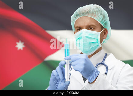 Arzt mit Spritze in Händen und Flagge auf Hintergrund - Jordanien Stockfoto